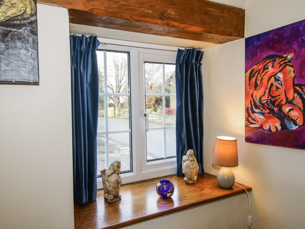 A living room with a window and sculptures at Marigold Cottage in Clun near Bishop's Castle