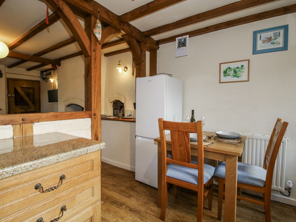 A dining area with a table and chairs at Marigold Cottage in Clun near Bishop's Castle