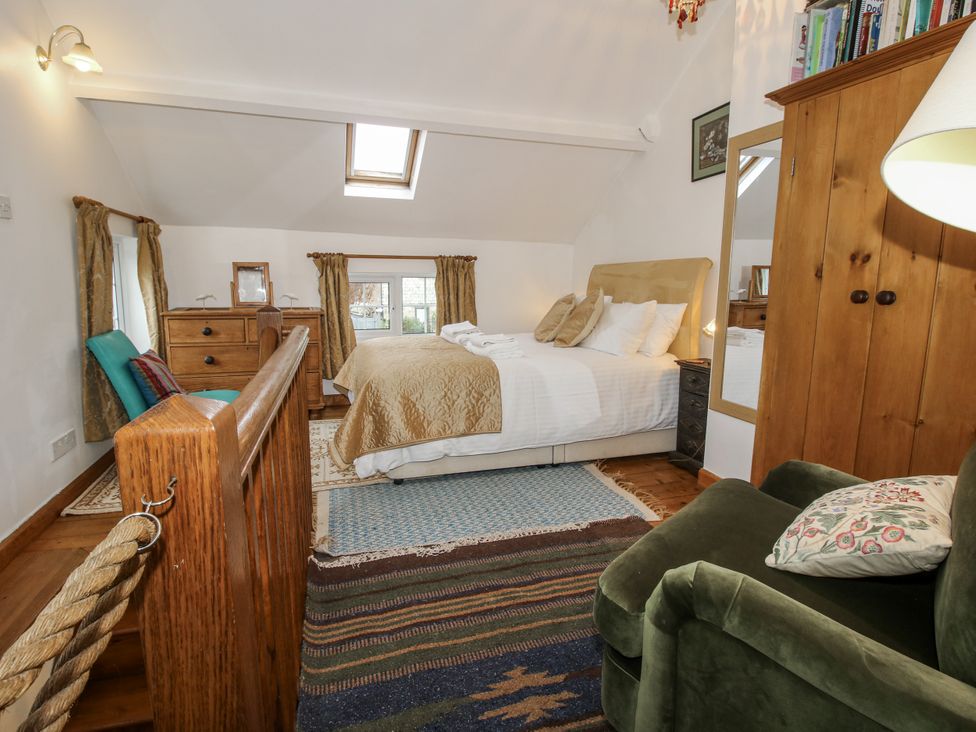 A bedroom with a bed and dresser at Marigold Cottage in Clun near Bishop's Castle
