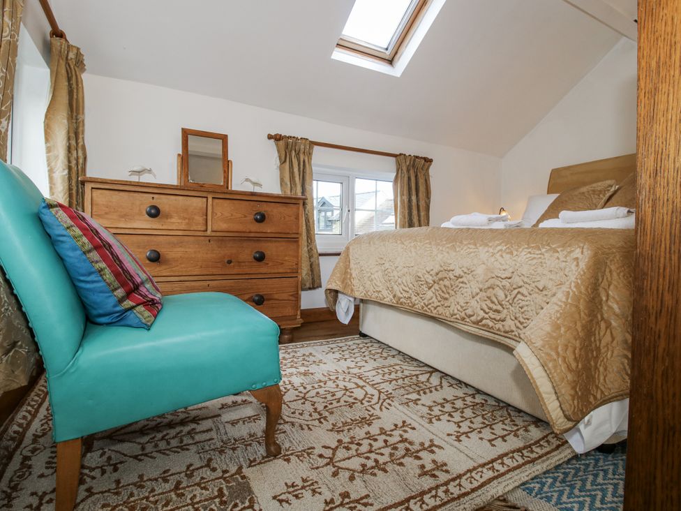 A bedroom with a bed and dresser at Marigold Cottage in Clun near Bishop's Castle