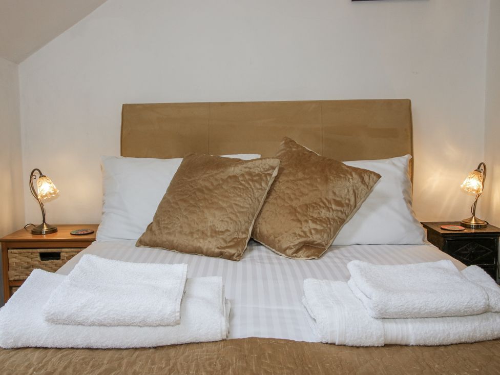 A bed with pillows and towels at Marigold Cottage in Clun near Bishop's Castle