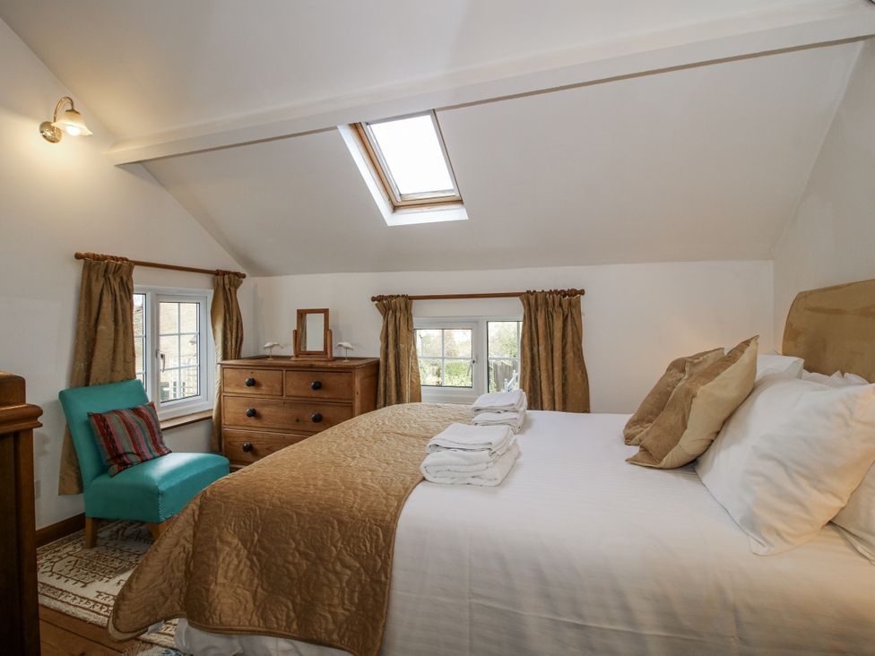 A bedroom with a bed and chair at Marigold Cottage Clun near Bishop's Castle