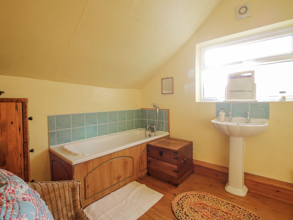 A bathroom with a bathtub and sink at Marigold Cottage in Clun near Bishop's Castle