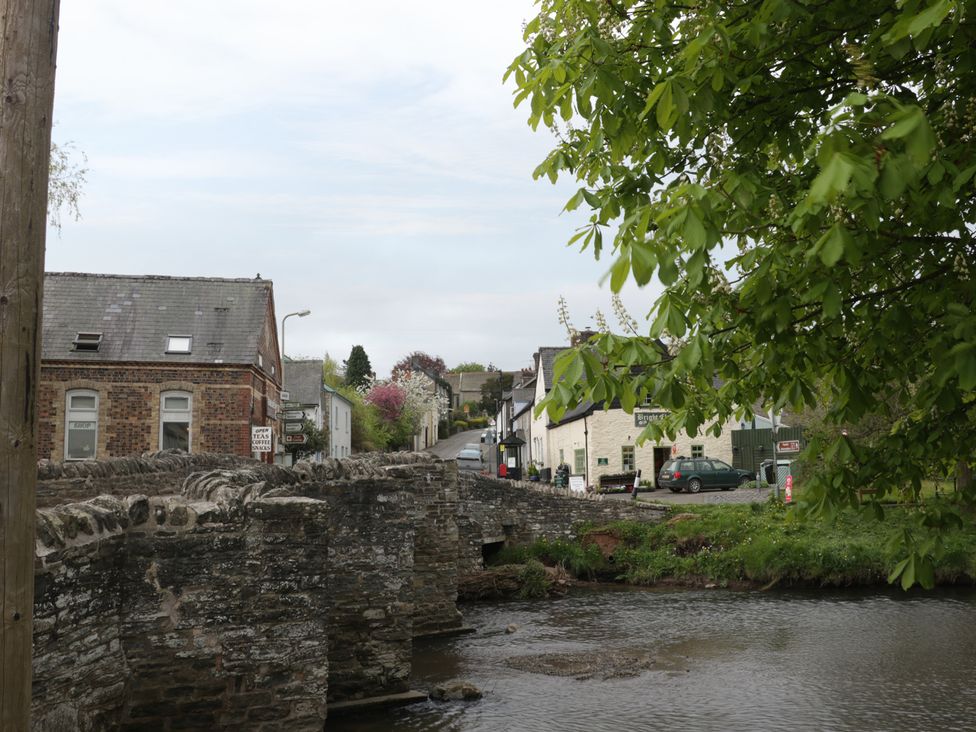 A view of houses and a bridge over a river at Marigold Cottage in Clun near Bishop's Castle