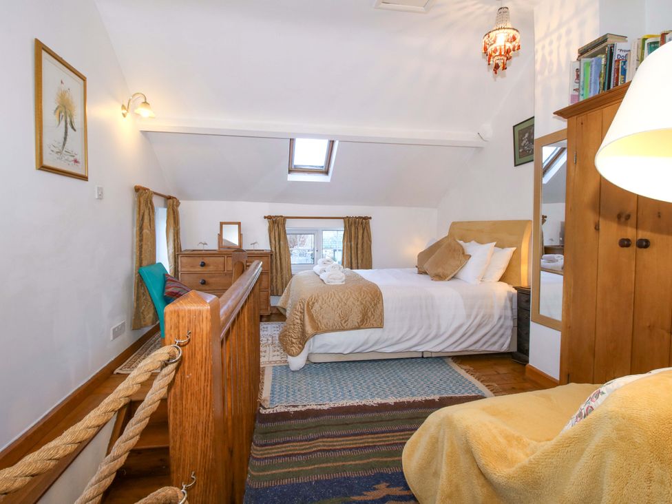 A bedroom with a bed and dresser at Marigold Cottage in Clun near Bishop's Castle