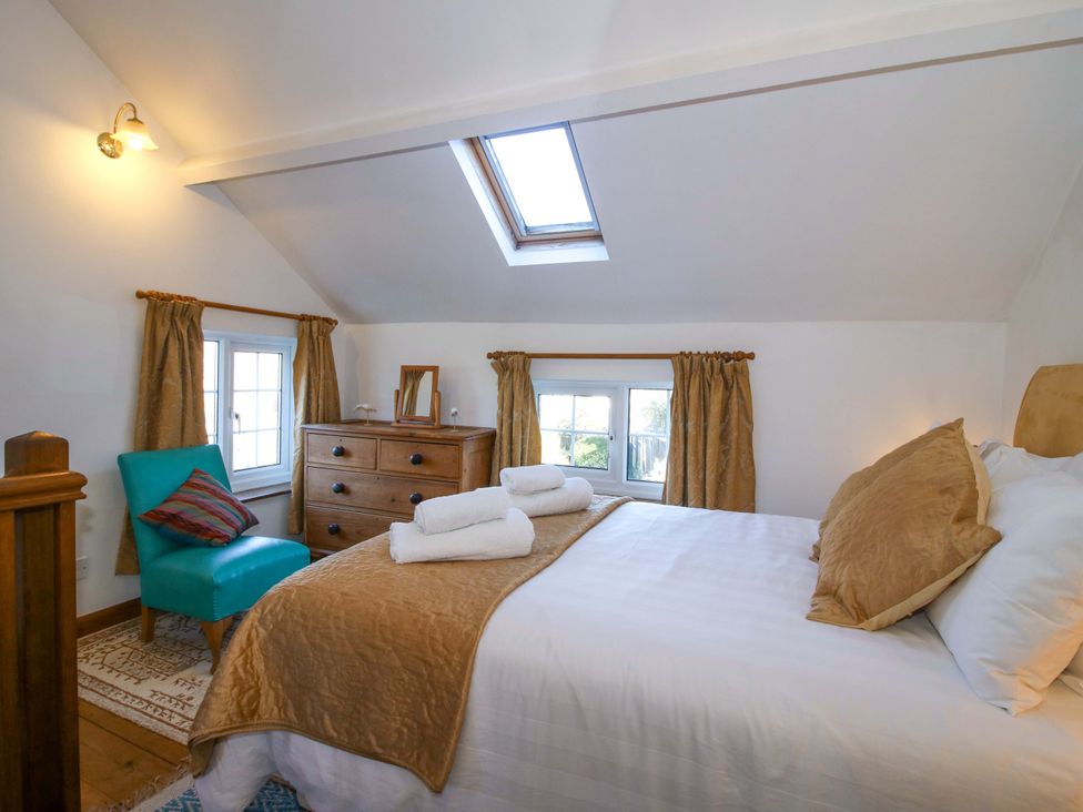 A bedroom with a bed and dresser at Marigold Cottage in Clun near Bishop's Castle