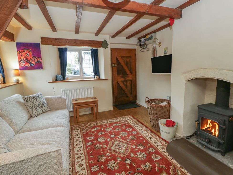 A living room with a fireplace and sofa at Marigold Cottage in Clun near Bishop's Castle
