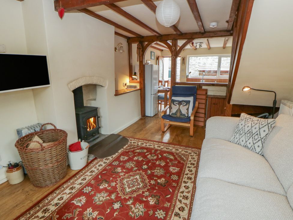 A living room with a fireplace and sofa at Marigold Cottage in Clun near Bishop's Castle