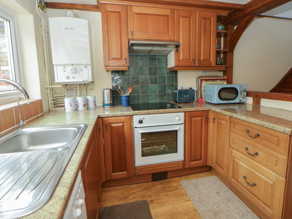A kitchen with a sink, oven, and microwave at Marigold Cottage Clun near Bishop's Castle