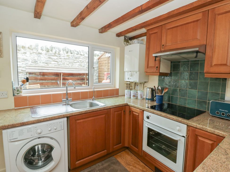 A kitchen with a washing machine and oven at Marigold Cottage in Clun near Bishop's Castle