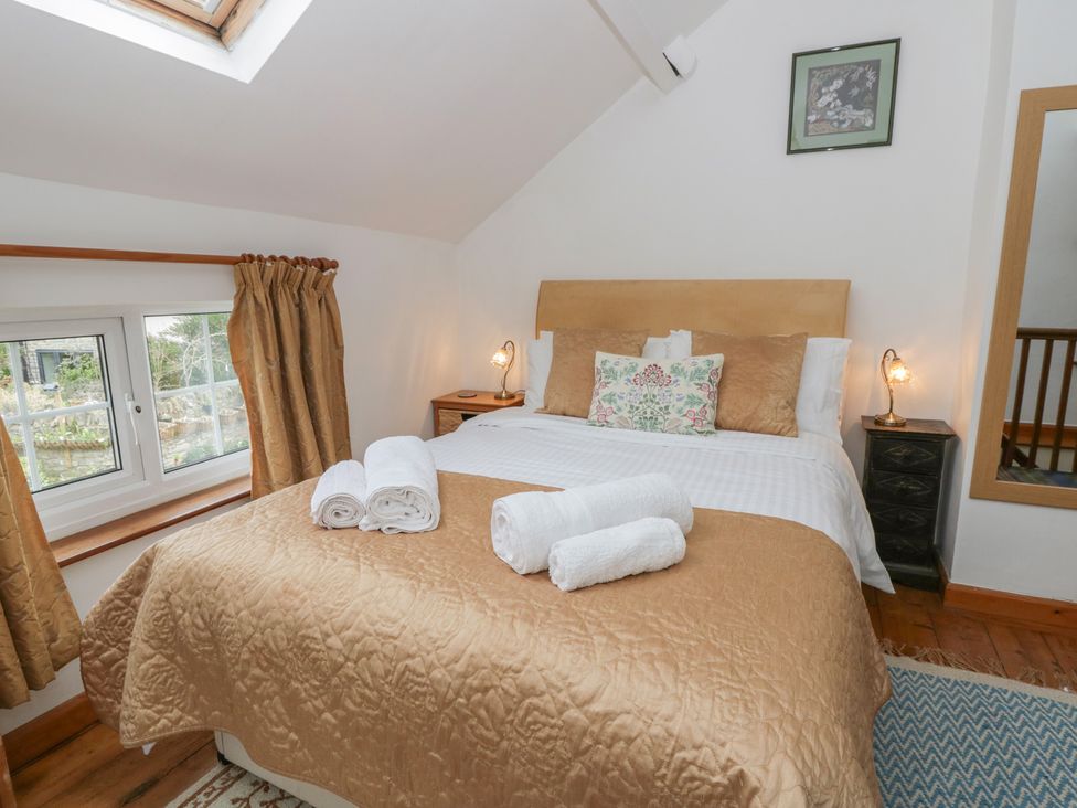 A bedroom with a bed and towels at Marigold Cottage in Clun near Bishop's Castle