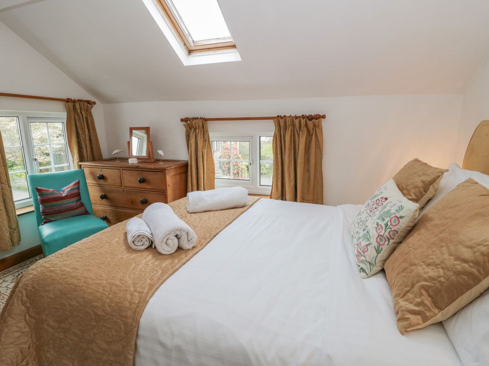 A bedroom with a bed and dressing table at Marigold Cottage in Clun near Bishop's Castle