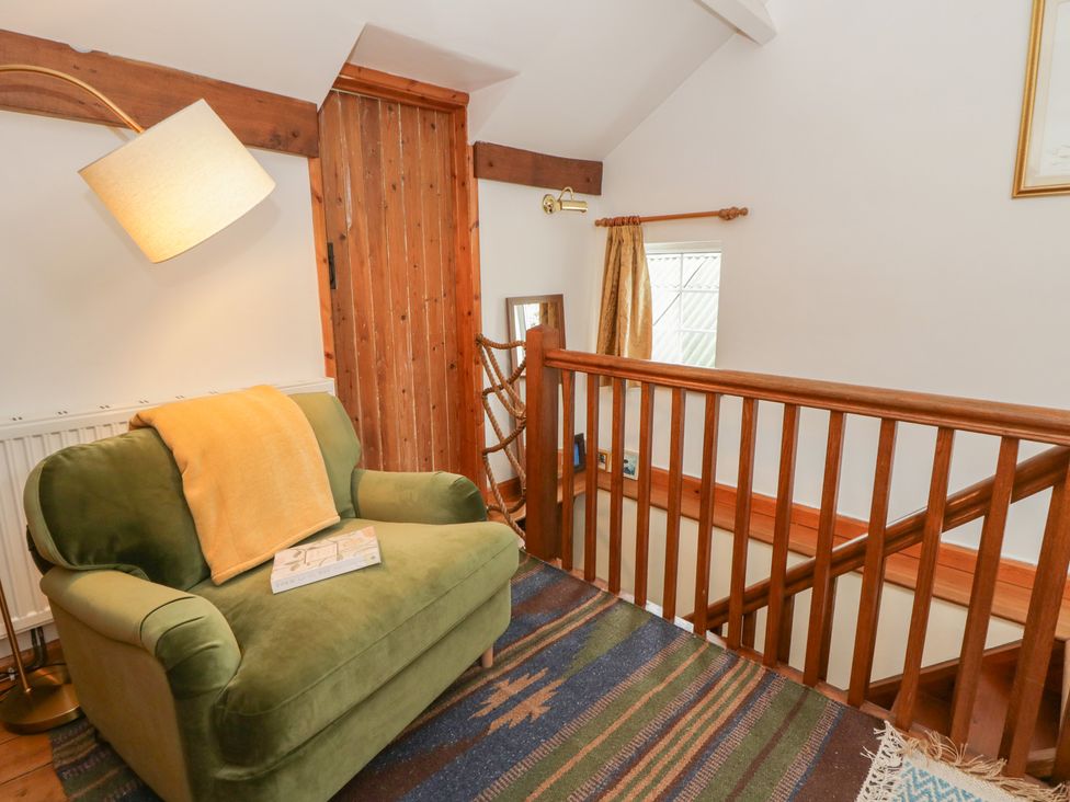 A landing area with an armchair and lamp at Marigold Cottage in Clun near Bishop's Castle
