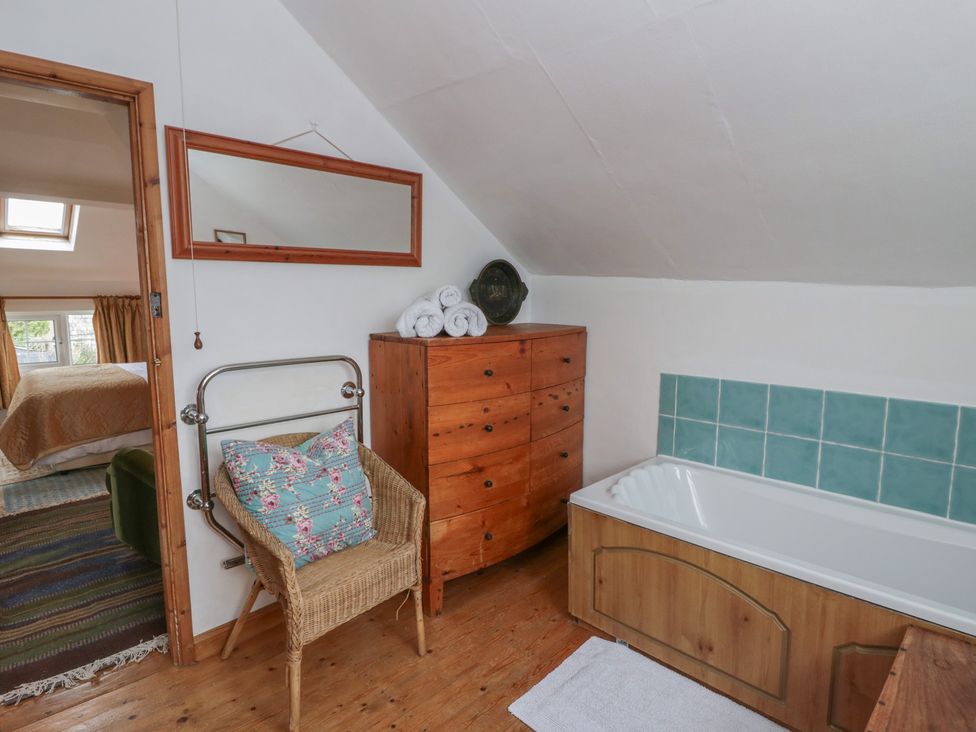 A bathroom with a bath and towels at Marigold Cottage in Clun near Bishop's Castle