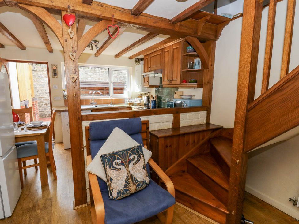 A kitchen with a staircase and dining area at Marigold Cottage Clun near Bishop's Castle