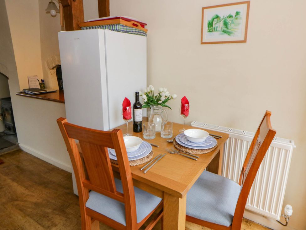 A dining area with a small table and chairs at Marigold Cottage in Clun near Bishop's Castle