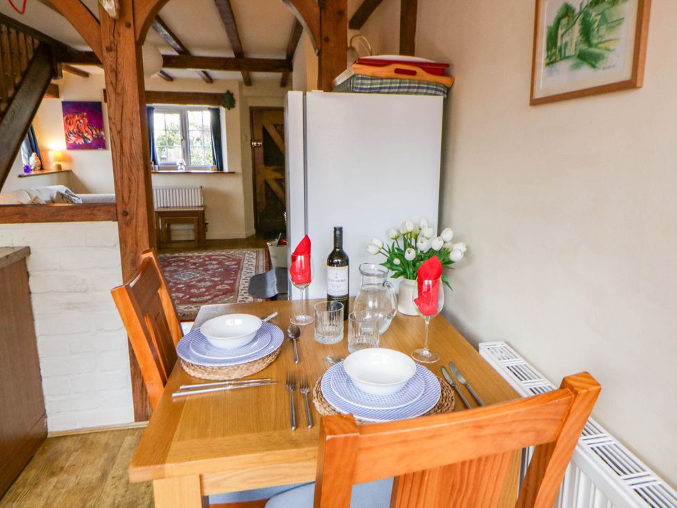 A dining room with a table set for two at Marigold Cottage in Clun near Bishop's Castle