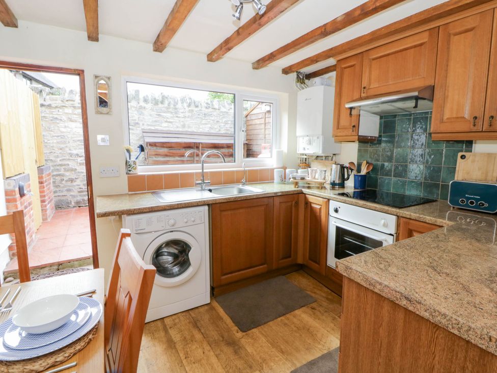 A kitchen with a washing machine and a sink at Marigold Cottage in Clun near Bishop's Castle