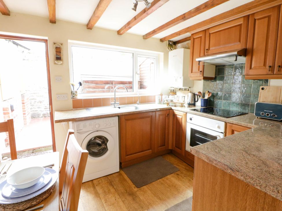 A kitchen with cabinets and appliances at Marigold Cottage in Clun near Bishop's Castle