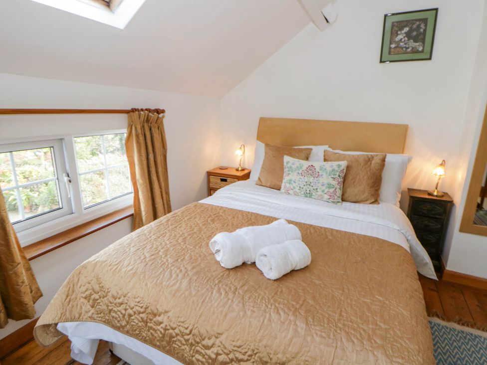 A bedroom with a bed and bedside table at Marigold Cottage Clun near Bishop's Castle