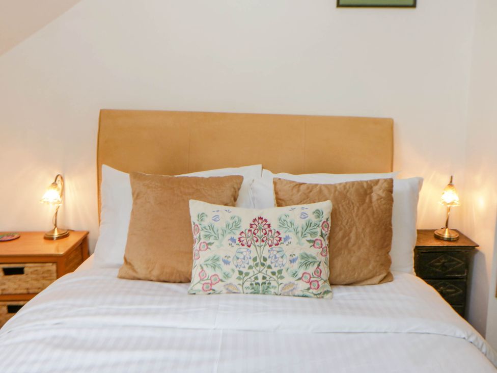 A bedroom with a bed and nightstands at Marigold Cottage in Clun near Bishop's Castle