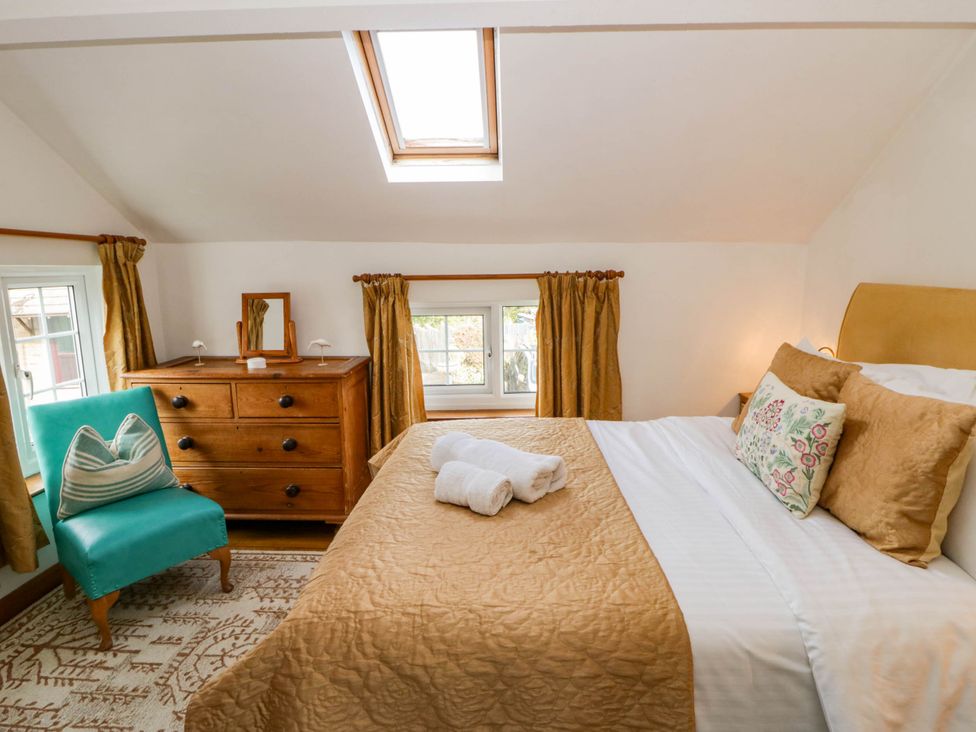 A bedroom with a bed and dresser at Marigold Cottage in Clun near Bishop's Castle