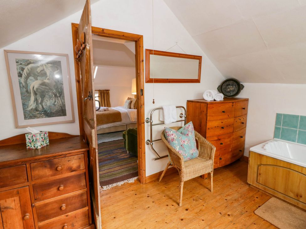 A bathroom with a dresser and bathtub at Marigold Cottage in Clun near Bishop's Castle