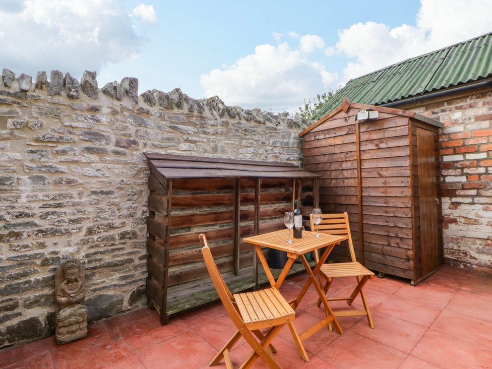 A garden with a wooden table and chairs at Marigold Cottage in Clun near Bishop's Castle