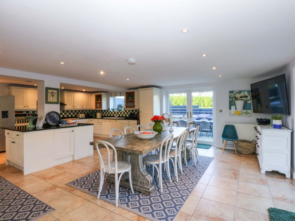 A kitchen with a dining table and chairs at Nant-yr-Rhedyn Red Wharf Bay