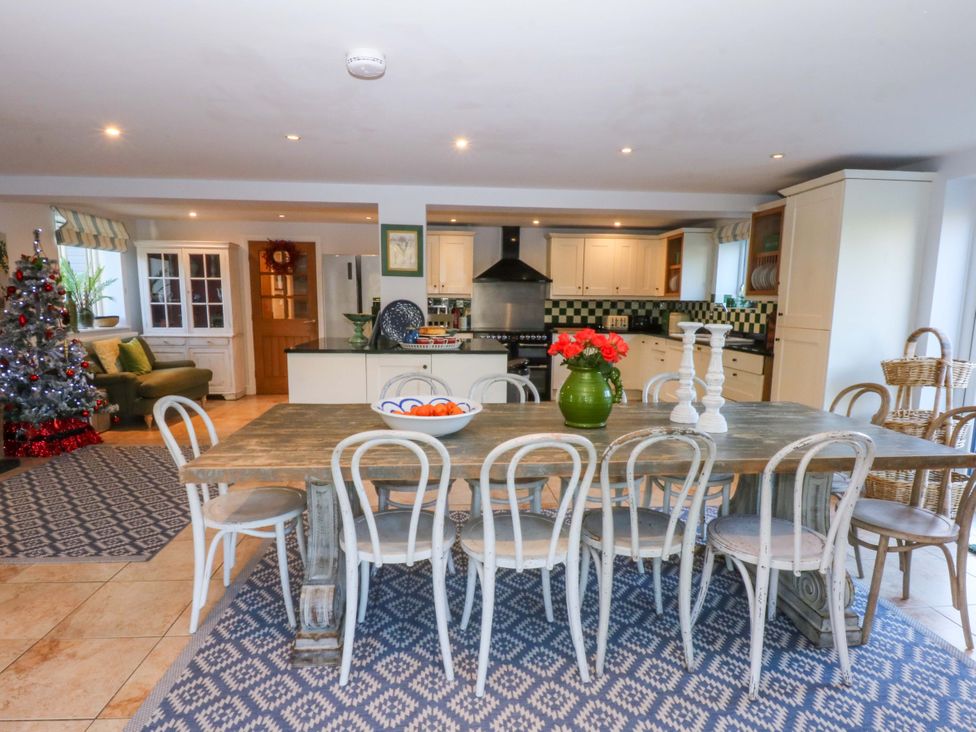 A kitchen with a dining table and chairs at Nant-yr-Rhedyn in Red Wharf Bay