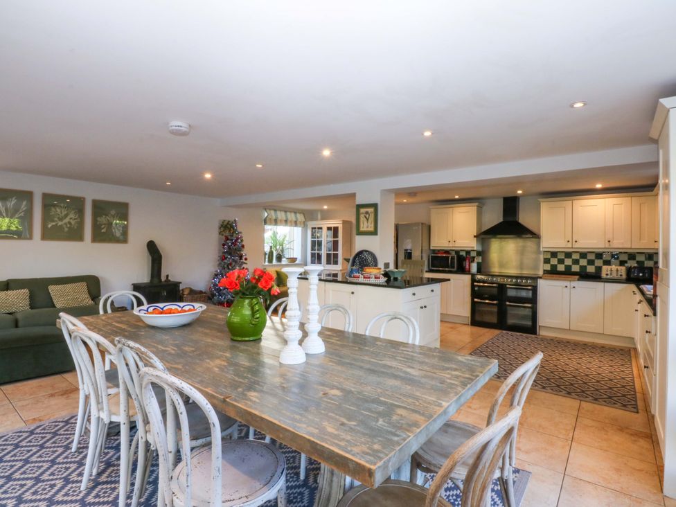 A kitchen with a dining area and appliances at Nant-yr-Rhedyn in Red Wharf Bay