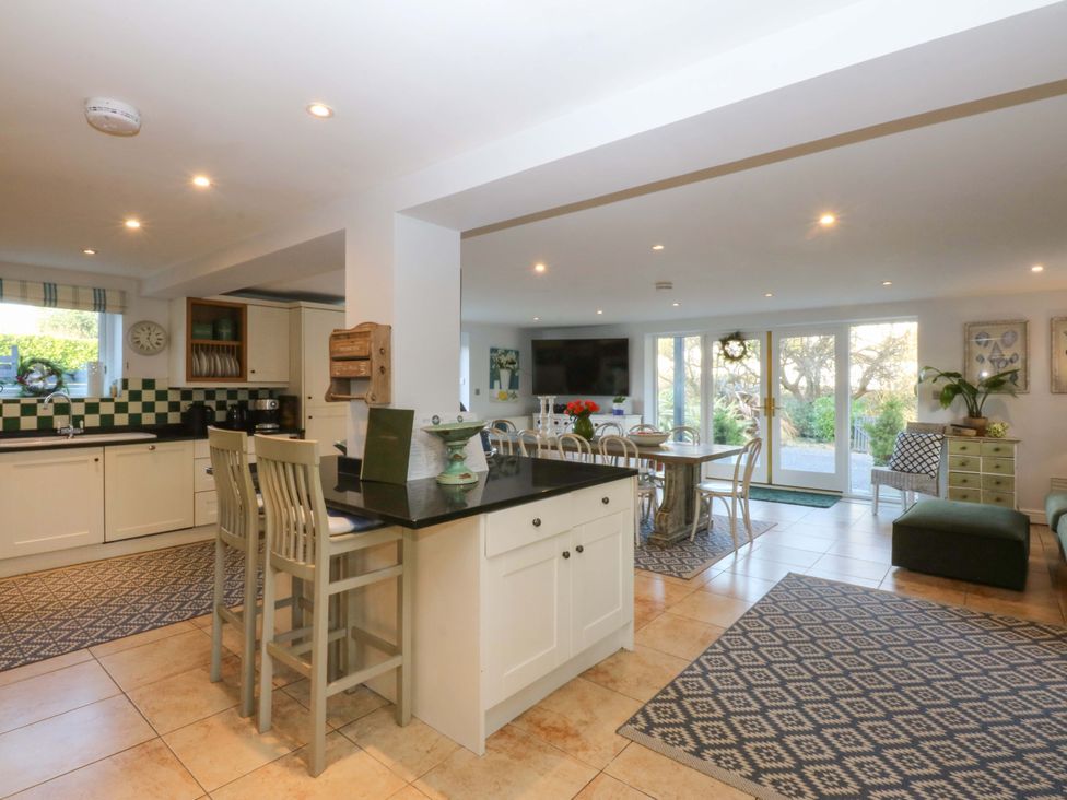 A kitchen with dining area and sofa at Nant-yr-Rhedyn in Red Wharf Bay