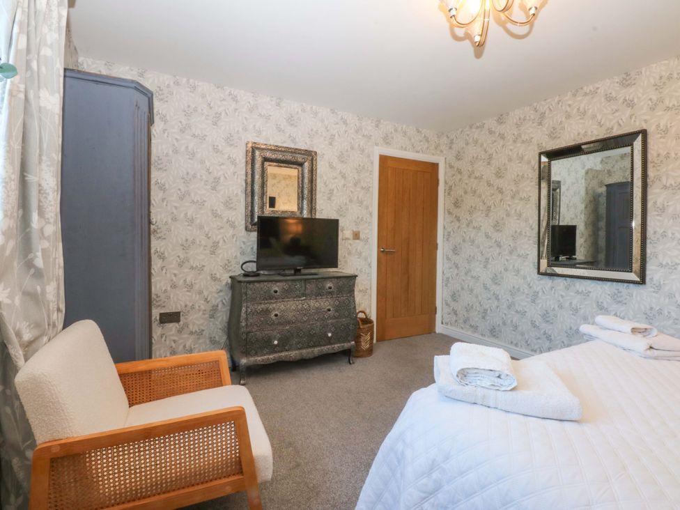 A bedroom with a bed and television at Nant-yr-Rhedyn in Red Wharf Bay