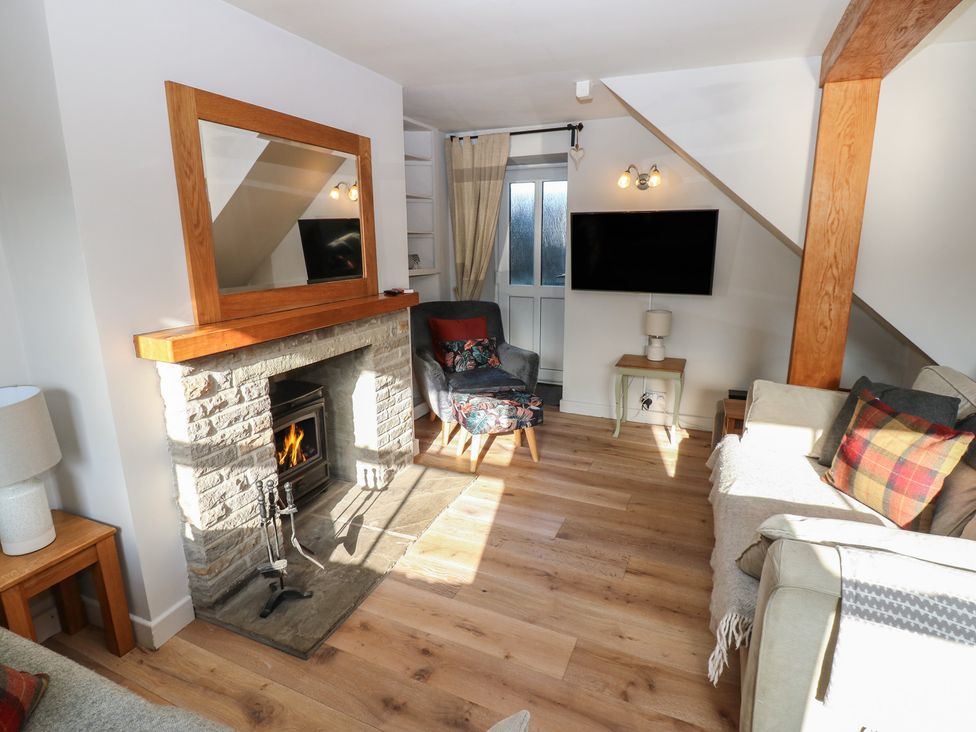 A living room with a fireplace and television at Hillside View in Hawes