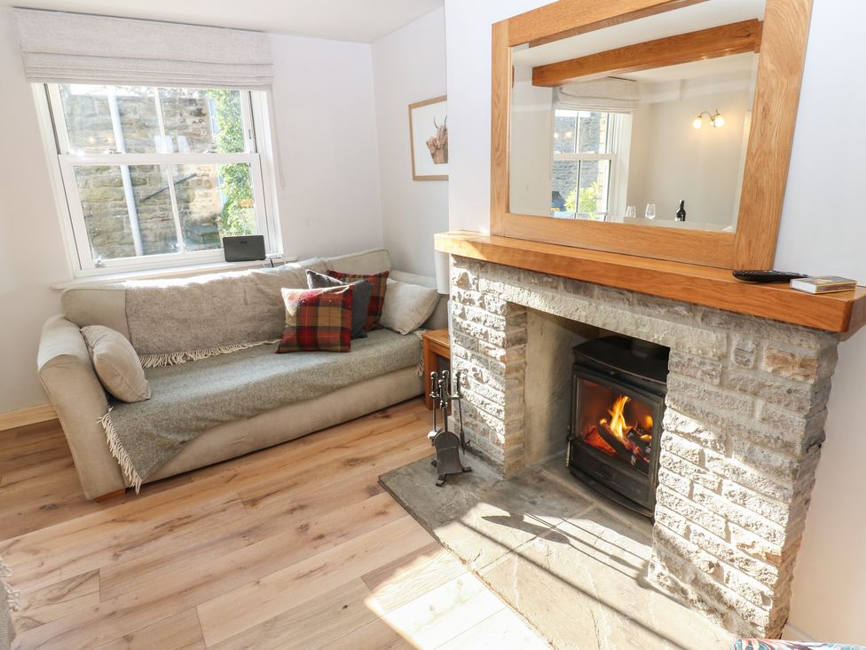 A sitting room with a fireplace and sofa at Hillside View in Hawes