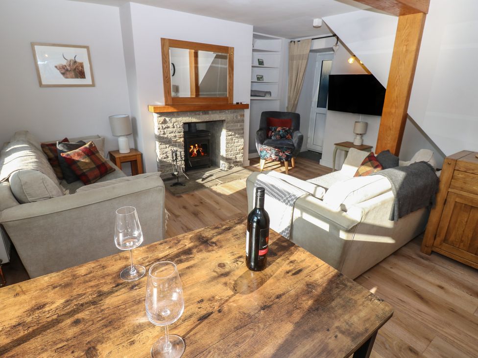 A living room with a fireplace and seating area at Hillside View in Hawes