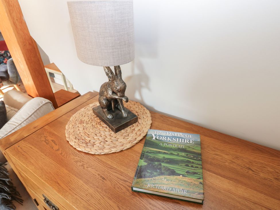 A lamp and book on a table in the living room at Hillside View Hawes