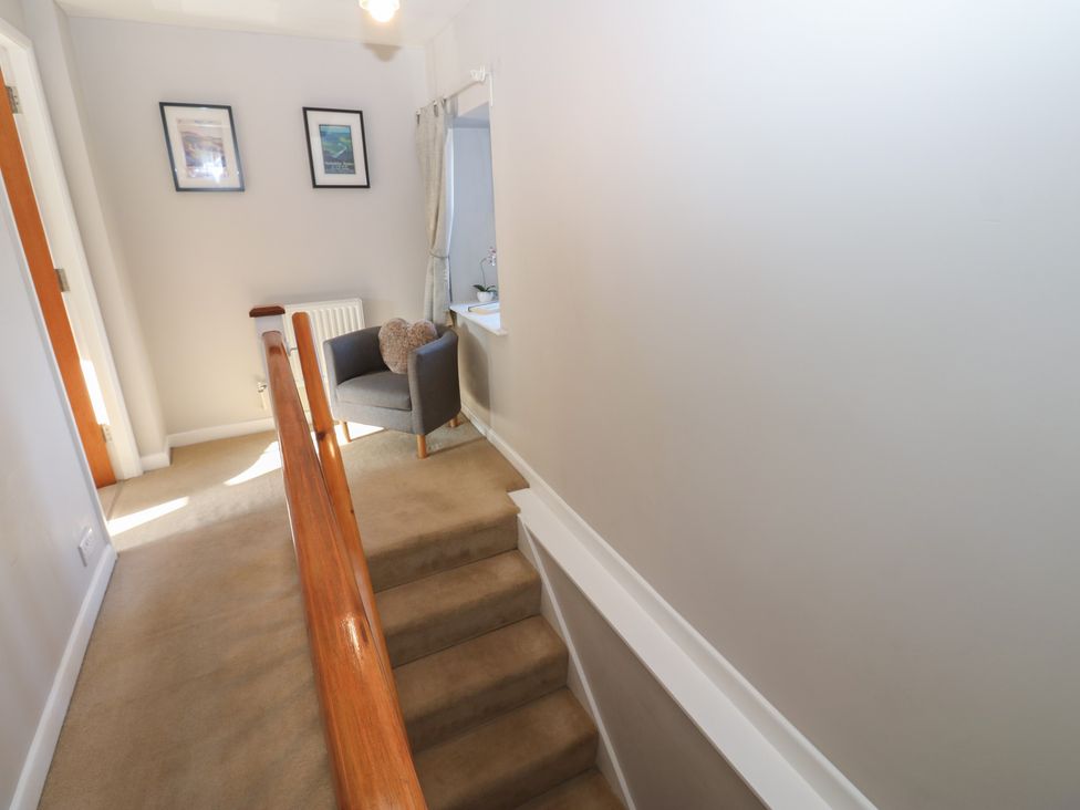 A hallway with stairs and an armchair at Hillside View in Hawes