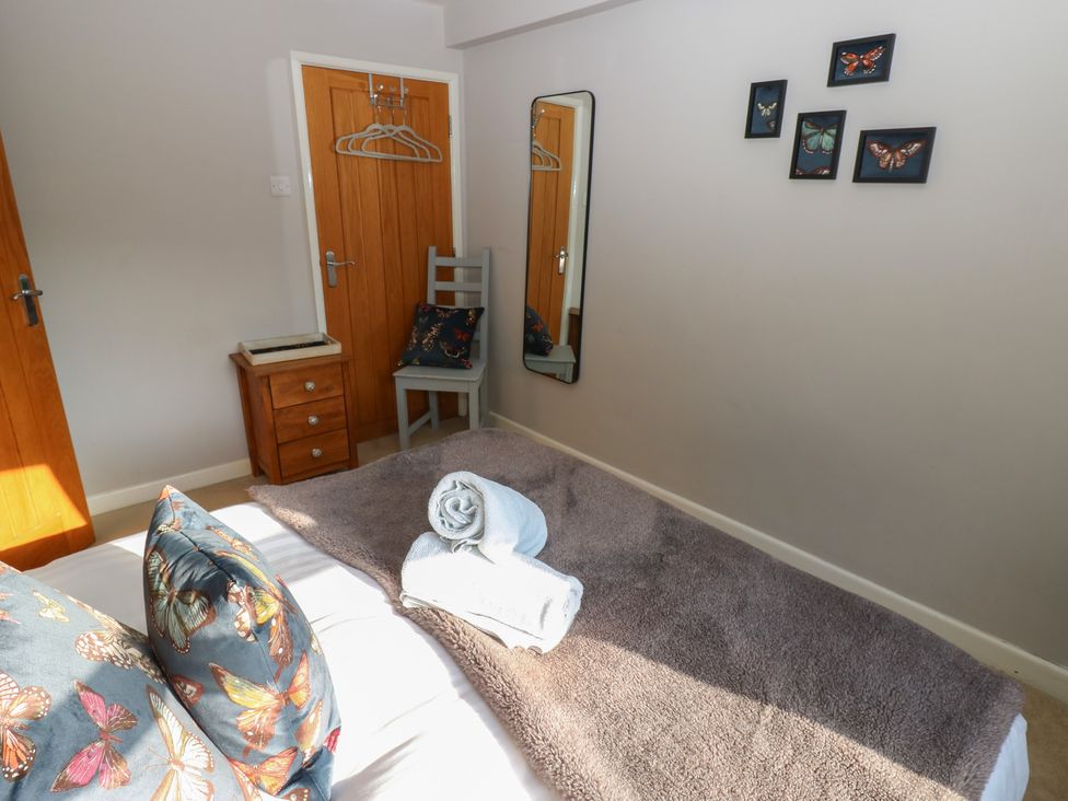 A bedroom with a bed and mirror at Hillside View in Hawes