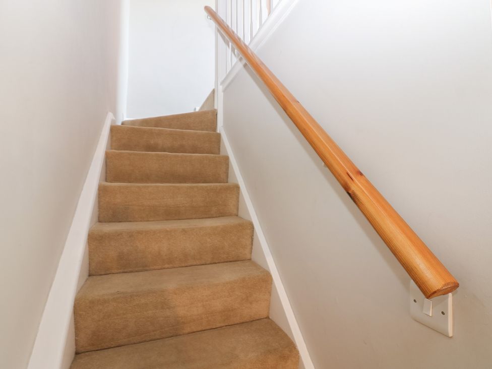 A staircase with a wooden handrail at Hillside View in Hawes