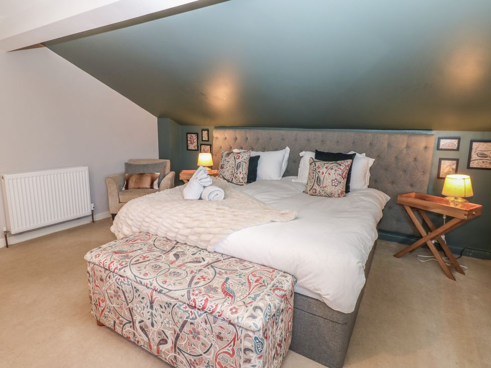 A bedroom with a bed and armchair at Hillside View in Hawes