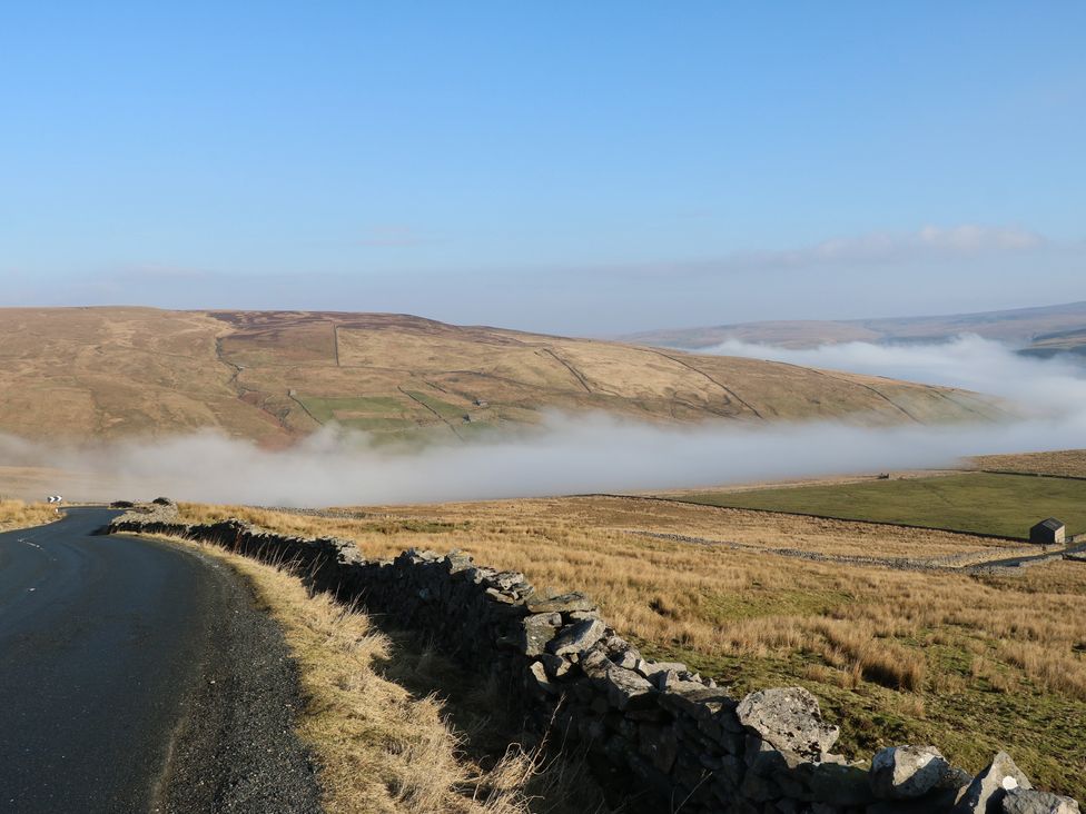 A road with a view of hills and fog at Hillside View in Hawes