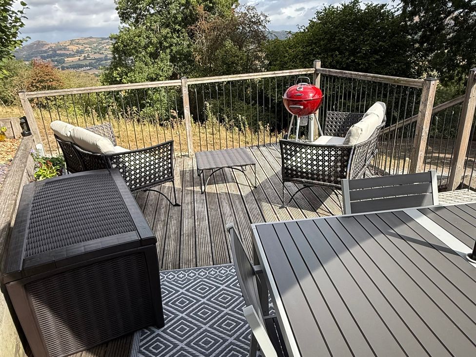 An outdoor seating area with chairs and a grill at Bishop's Castle Barn in Bishop's Castle