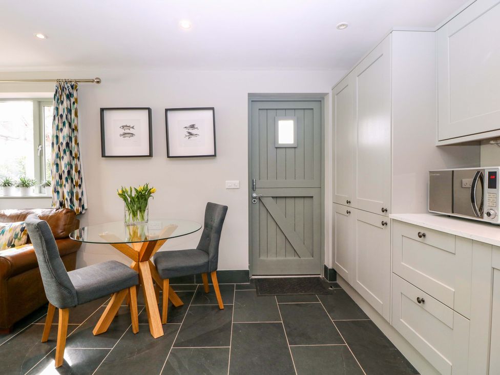 A kitchen with a table and chairs at The Lodge, Lower Trefedw in Pandy near Abergavenny