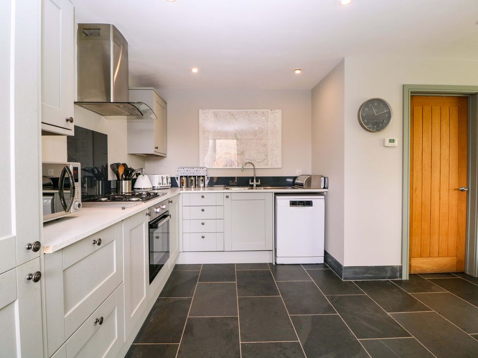 A kitchen with appliances and cabinets at The Lodge, Lower Trefedw in Pandy near Abergavenny