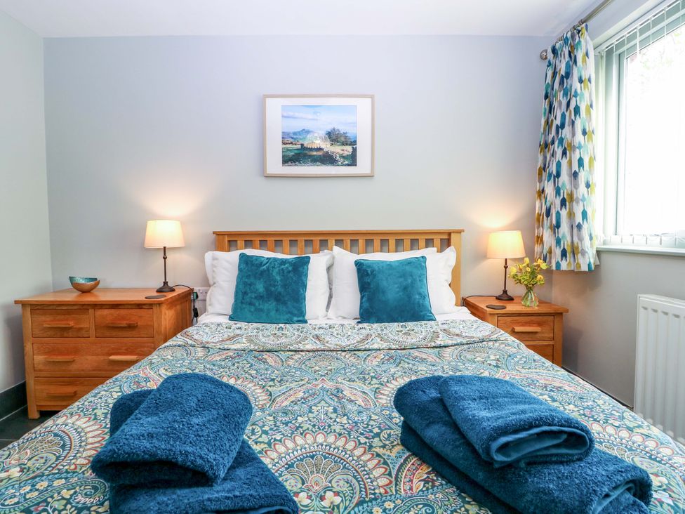 A bedroom with a bed and nightstands at The Lodge, Lower Trefedw in Pandy near Abergavenny