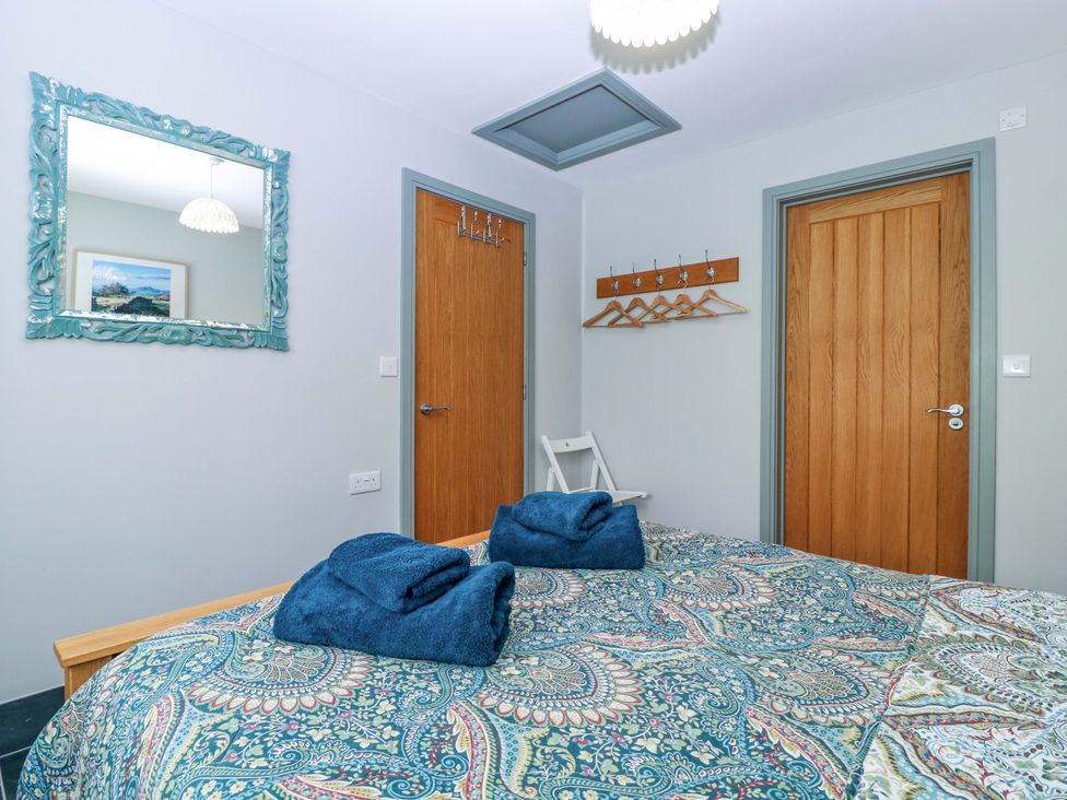 A bedroom with a bed and towels on top at The Lodge, Lower Trefedw in Pandy near Abergavenny