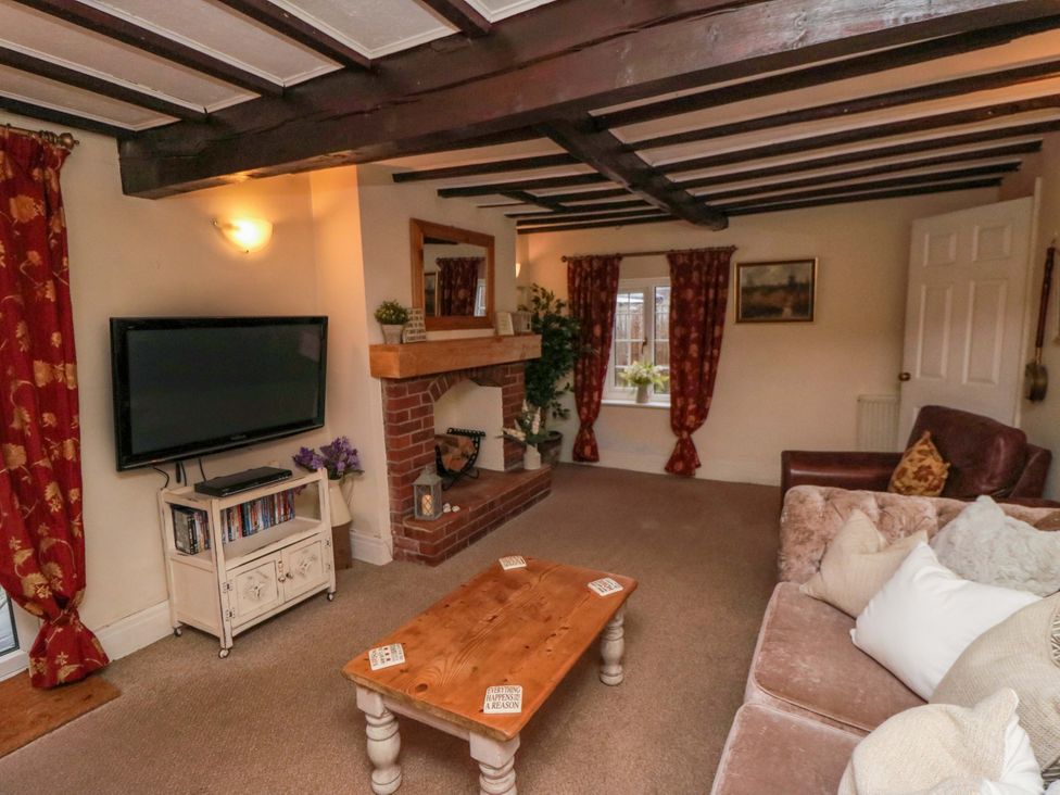 A living room with a television and fireplace at Jasmine Cottage in Dalton Near Thirsk