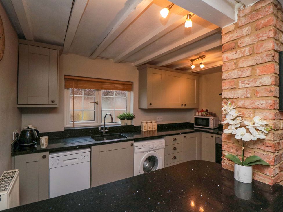 A kitchen with cabinets and appliances at Jasmine Cottage in Dalton Near Thirsk