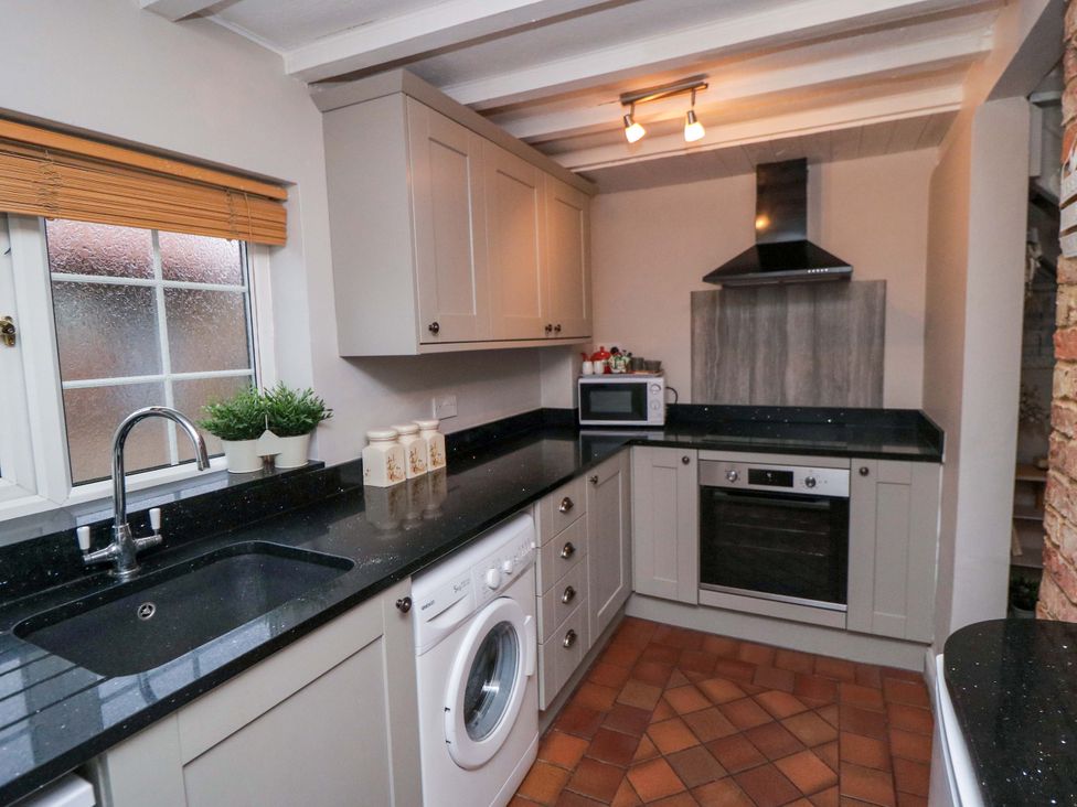 A kitchen with appliances and cabinets at Jasmine Cottage in Dalton Near Thirsk